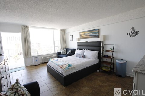 A bedroom with a large bed and a painting on the wall.