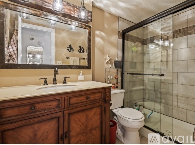 A bathroom with a wooden vanity and a white toilet.