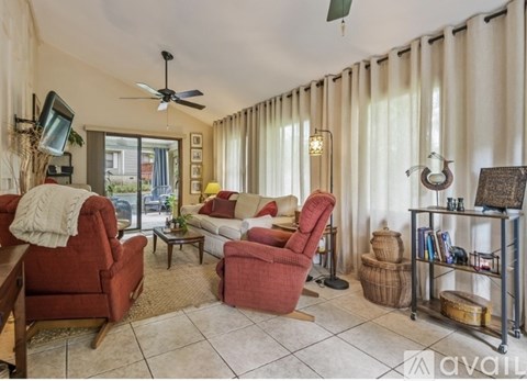 A living room with red chairs and a fan.