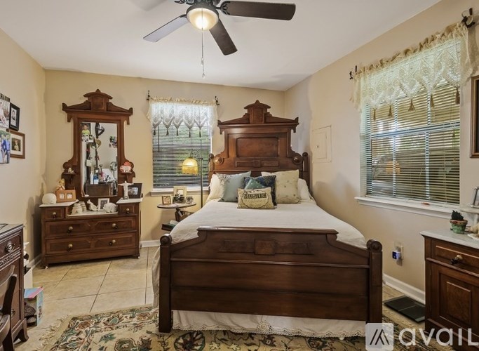 A bedroom with a large bed, a dresser, and a mirror.