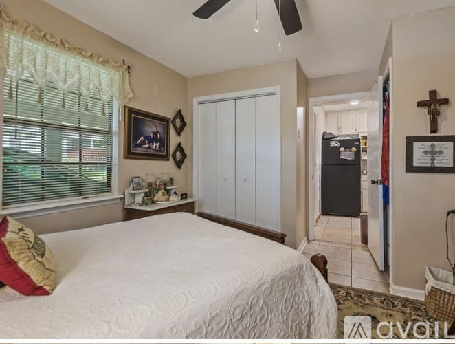 A bedroom with a large bed and a ceiling fan.