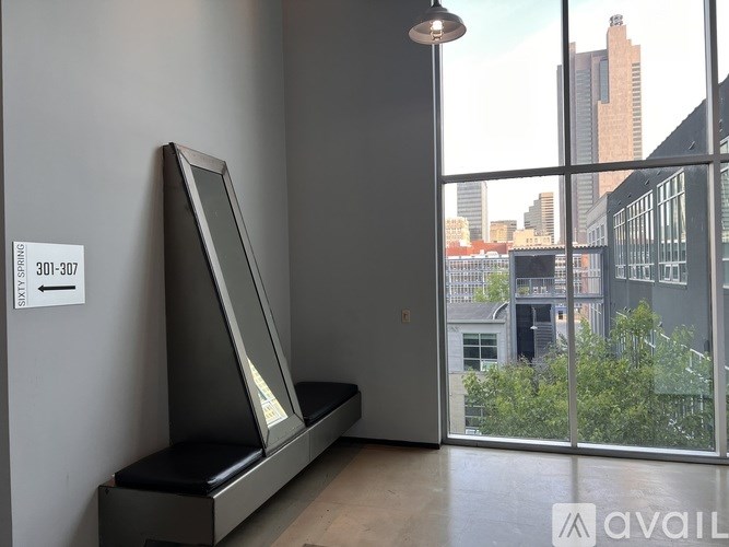 A room with a bench and a window overlooking a cityscape.