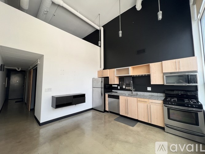 A kitchen with black walls and wooden cabinets is available for rent.