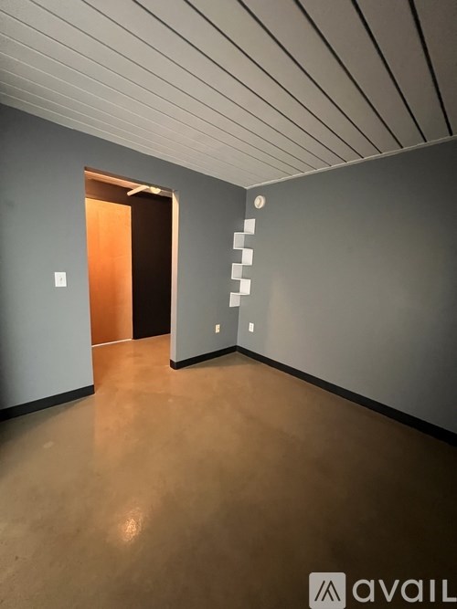 A hallway with a staircase on the right and a door on the left.
