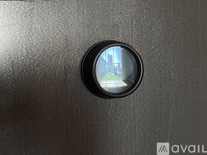 A round peephole on a dark grey door.