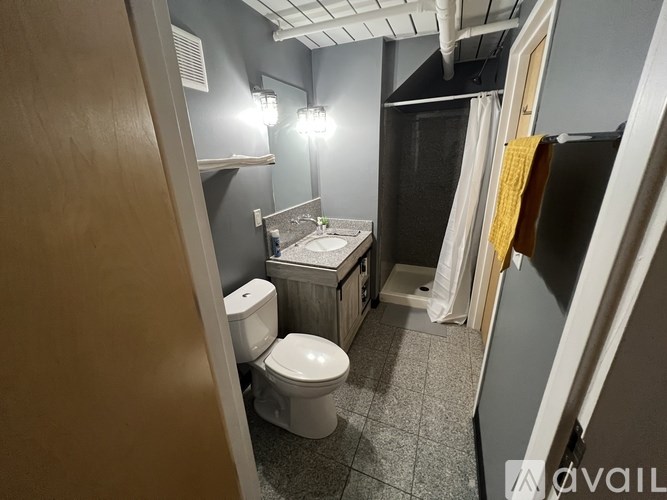 A small bathroom with a toilet, sink, and mirror.