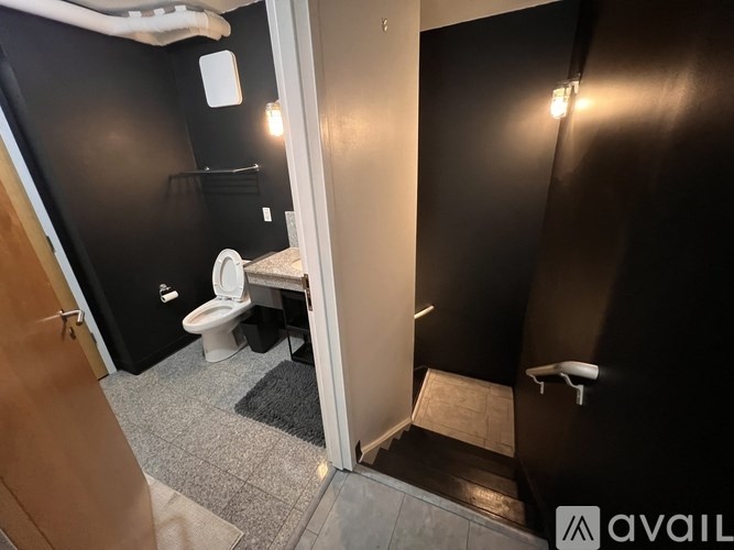 A bathroom with a toilet, sink, and mirror.