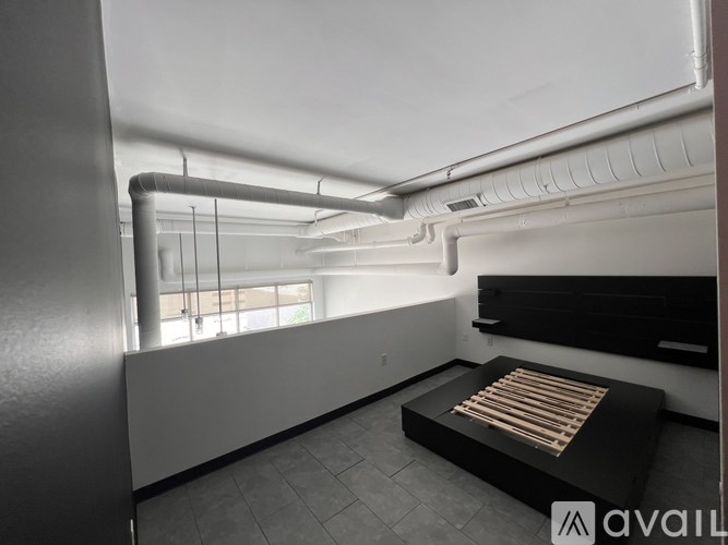 A room with a bed and a window with blinds.