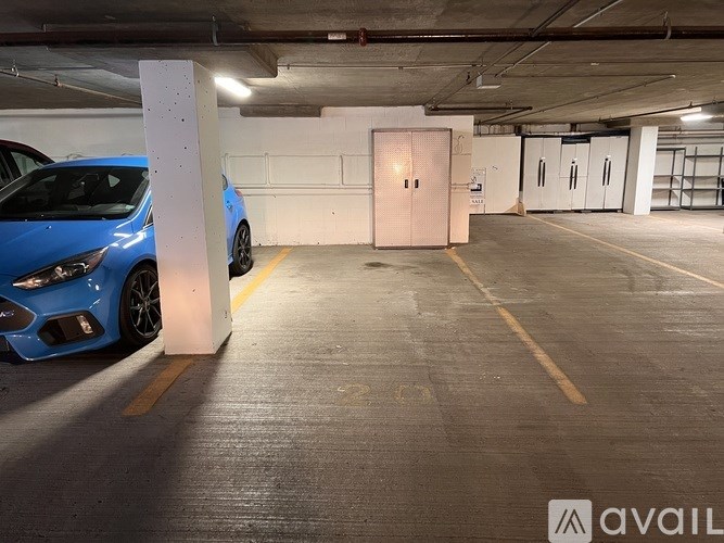 A blue car is parked in a parking garage.