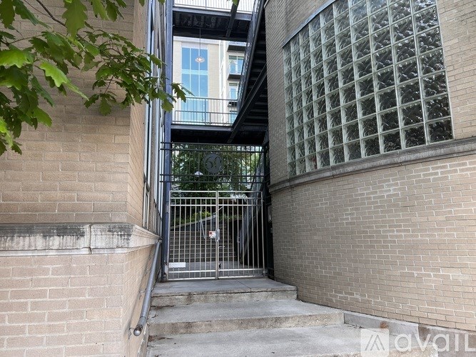 A metal gate blocks the entrance to a brick building.