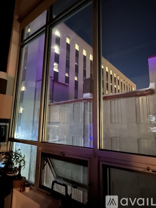 A window overlooks a cityscape at night.