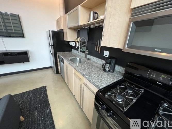 A kitchen with a black stove top oven and a black fridge.