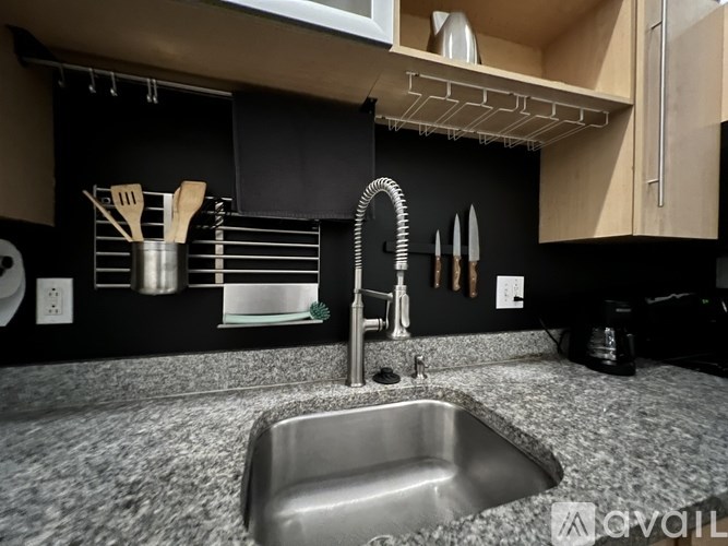 A kitchen with a sink and a black wall.