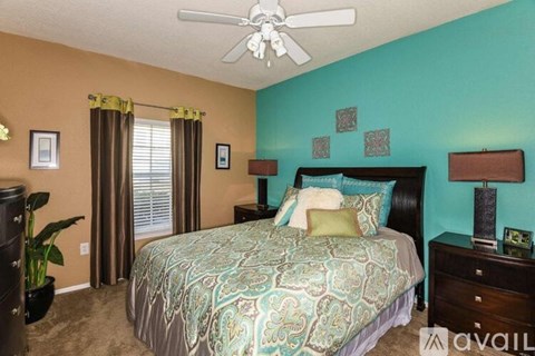 A bedroom with a bed, dresser, and ceiling fan.