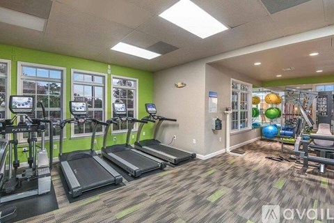 A gym with treadmills, elliptical machines, and other exercise equipment.