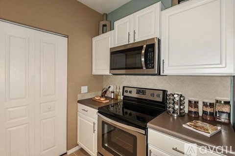 A kitchen with white cabinets and a black stove top oven.