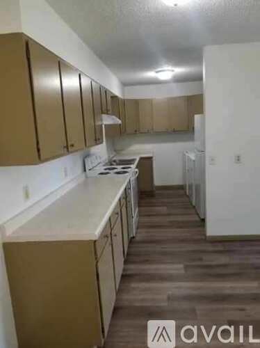 A kitchen with brown cabinets and white countertops.
