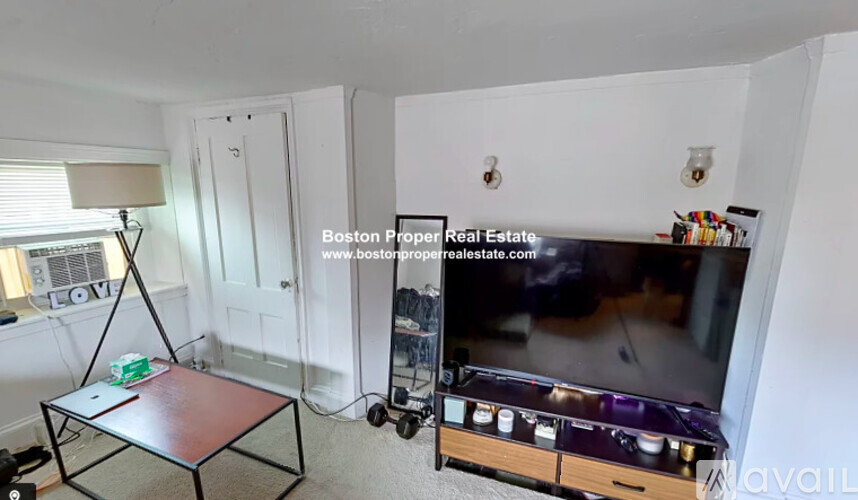 A living room with a flat screen TV and a coffee table.