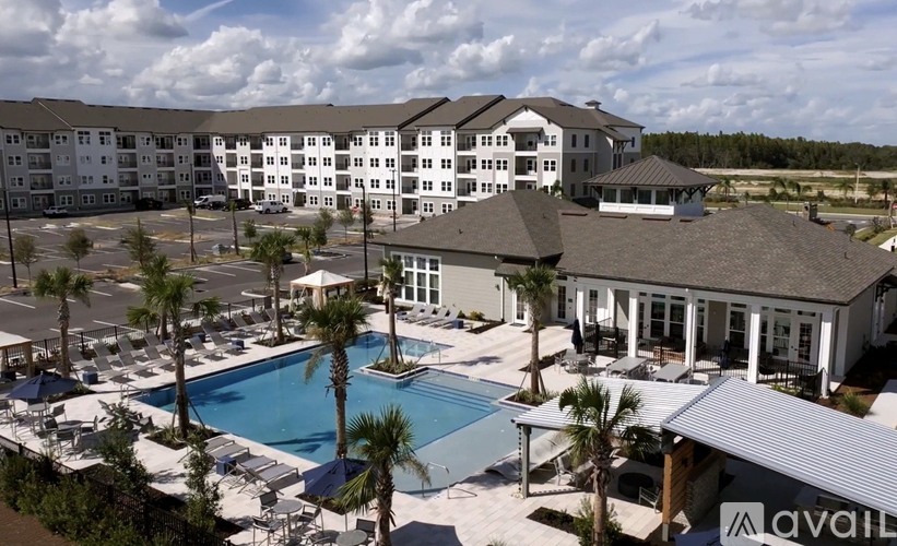 A large resort with a pool and palm trees.