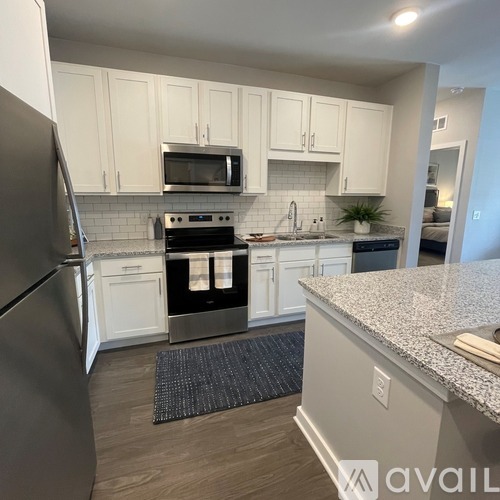A kitchen with white cabinets and a granite countertop.
