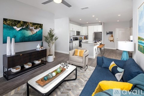 A modern living room with a large painting on the wall and a blue couch.