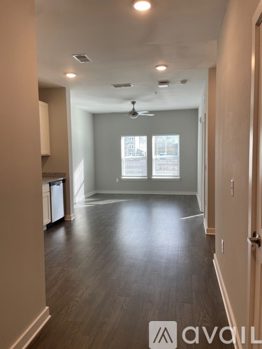 A spacious room with a ceiling fan and large windows.