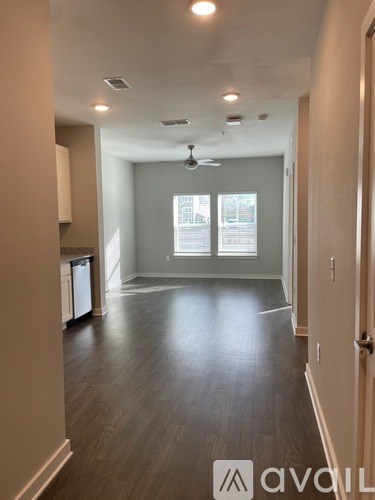 A spacious room with a ceiling fan and large windows.