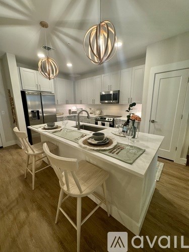 A modern kitchen with a dining table set for two.