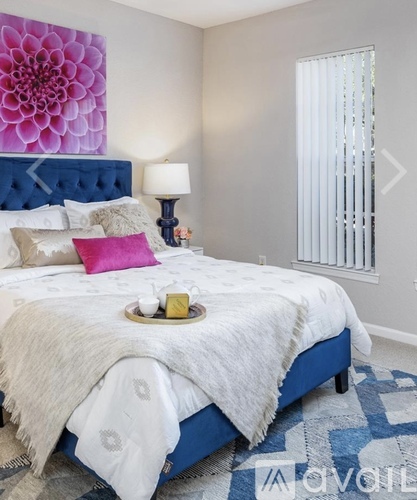 A bedroom with a blue headboard and a white bedspread.