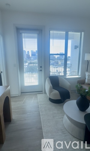 A living room with a large window and a view of the city.