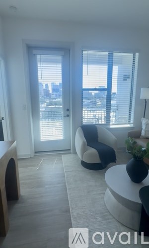 A living room with a large window and a view of the city.