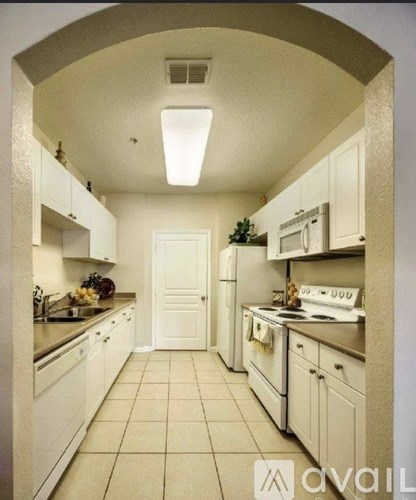 A kitchen with white cabinets and appliances.