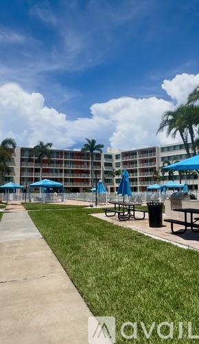 A modern building with a pool and lounge chairs.