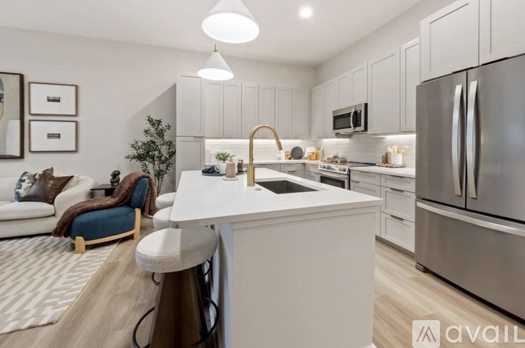 A modern kitchen with white cabinets and a black countertop.