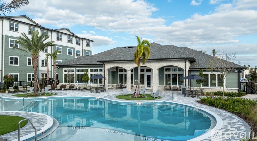 A large swimming pool in front of a building with a palm tree.