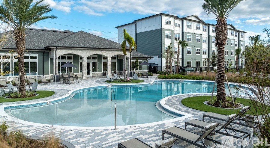 A large swimming pool surrounded by palm trees and lounge chairs.