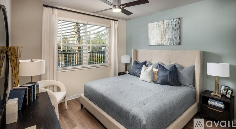 A bedroom with a large bed and a ceiling fan.