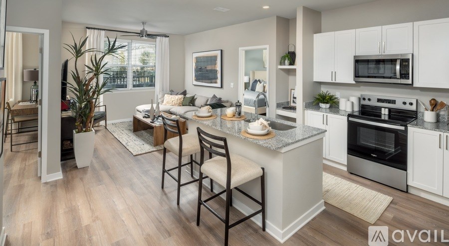 A modern kitchen with a dining area and a living room.