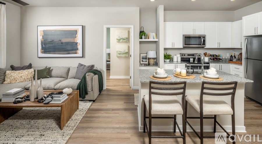 A modern kitchen with a dining table set for two.