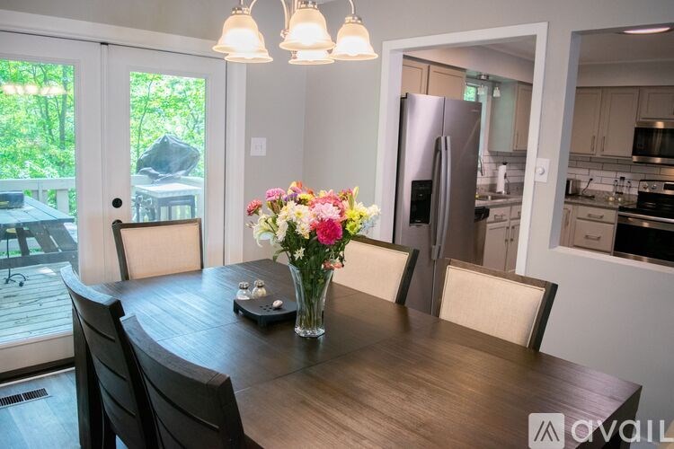 A kitchen with a table and chairs in the foreground and a refrigerator in the background.