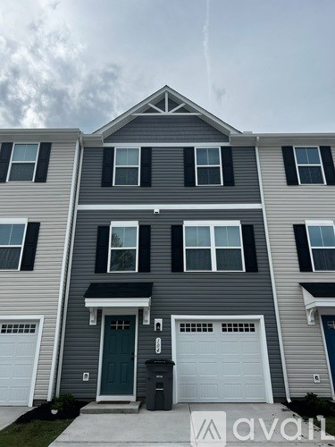 A two-story house with a garage on the first floor and a balcony on the second floor.
