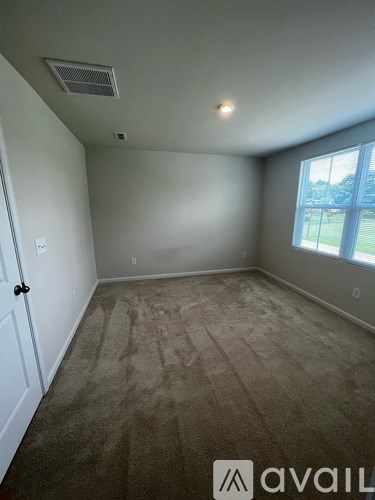 A room with a carpeted floor and a window.