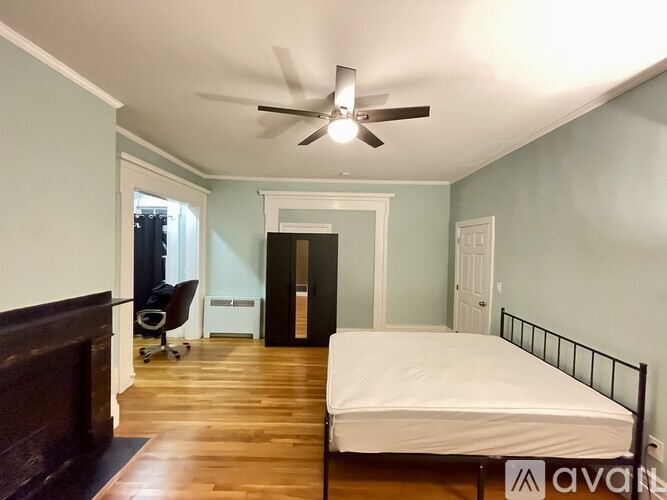 A bedroom with a bed, dresser, and chair.