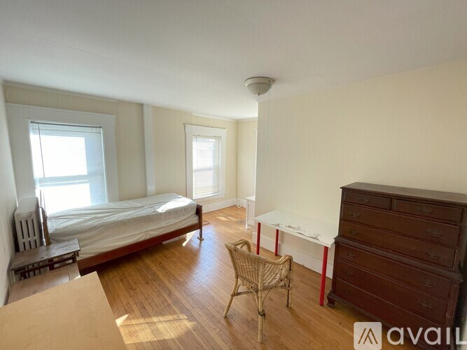 A bedroom with a bed, dresser, and chair.