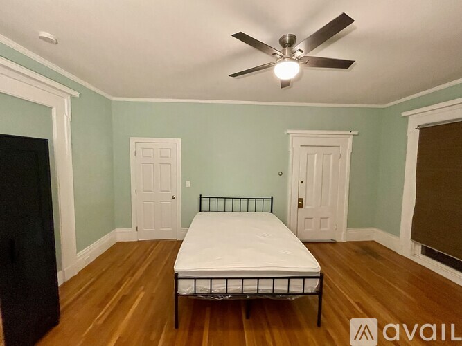 A room with a bed and a window with blinds.