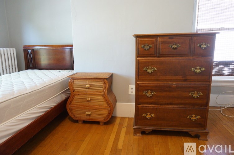 A room with a bed and a window with blinds.