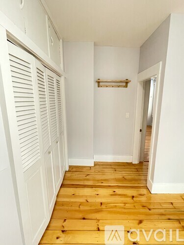 A room with a white door leading to a bedroom.