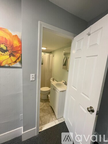 A bathroom with a toilet, sink, and mirror.
