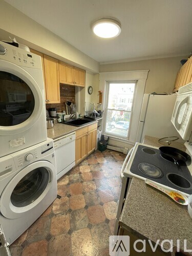 A kitchen with a washing machine and a stove top.