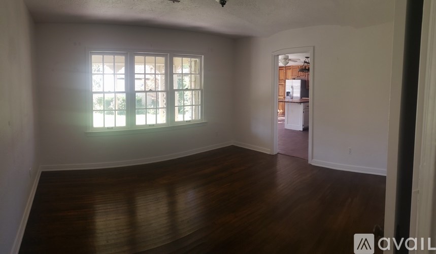 A room with wooden floors and a window letting in light.
